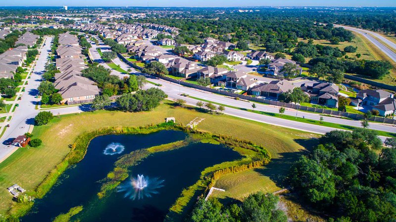 Suburbs of Round Rock, Texas, on a sunny day. You can find services that help with HOA liabilities.